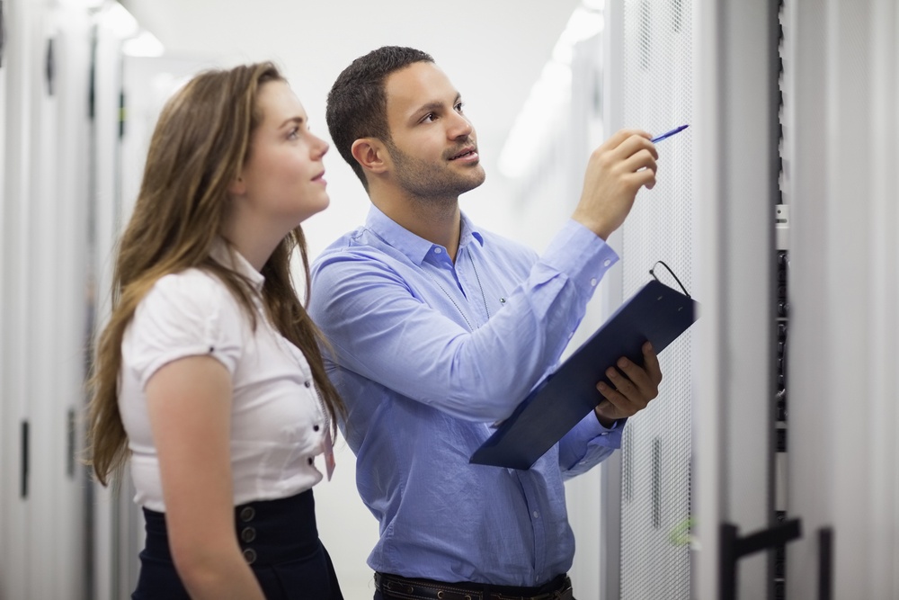 Technicians with clipbard looking at servers in data center.jpeg
